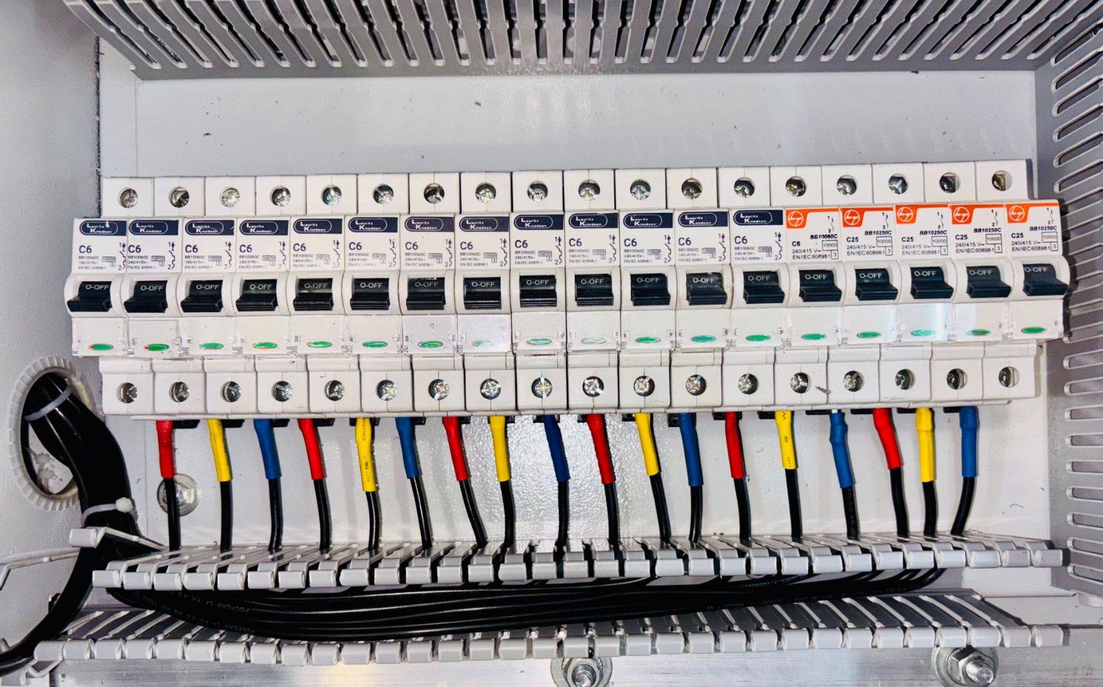 A finished load center fully wired, breakers labelled, conductors dressed and combed, deadfront ready to go back on — the work checkable at close range.
